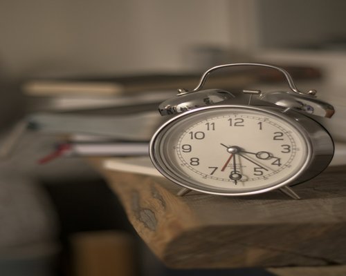 Analog clock on a nightstand showing bedtime